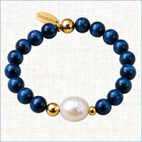 Luxury handmade blue tiger’s eye bracelet with baroque pearl, gold accents, and Teramasu signature tag.